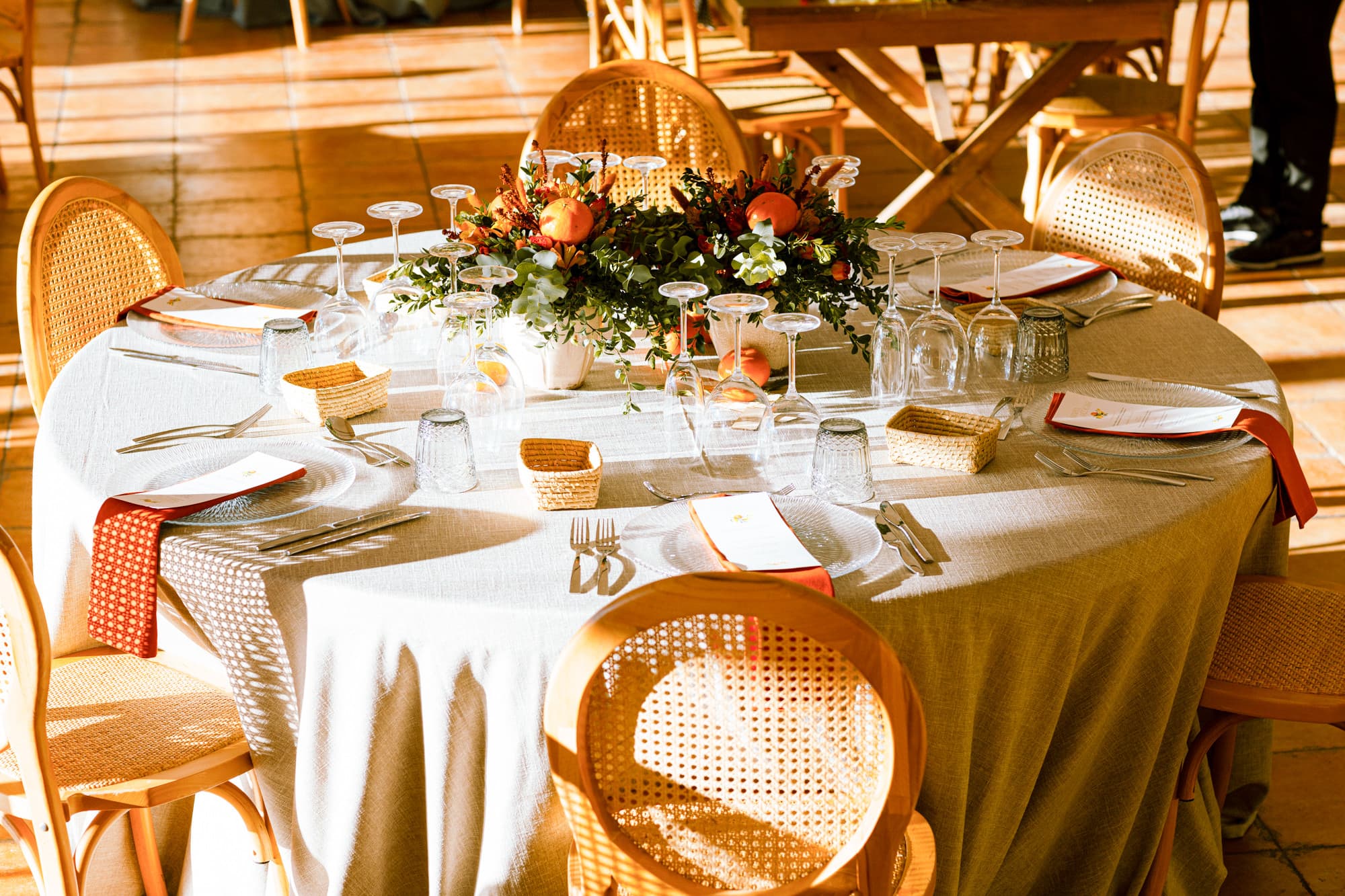 Mesa de boda con mantel tierra claro y frutales naranjas